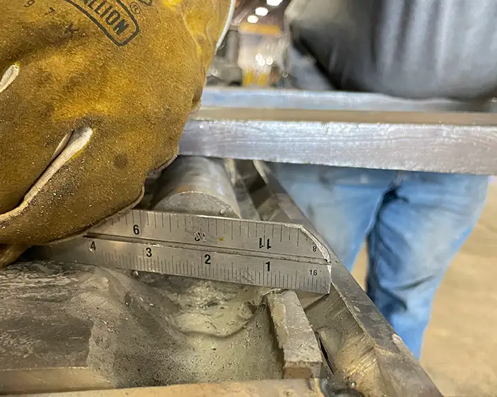 gloved hand holding ruler